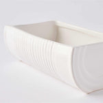 White ceramic bowl with textured surface on a light gray background