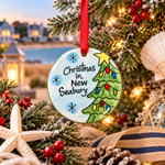 A flat, round ceramic Christmas ornament with a Christmas tree and the text 'Christmas in New Seabury'. 