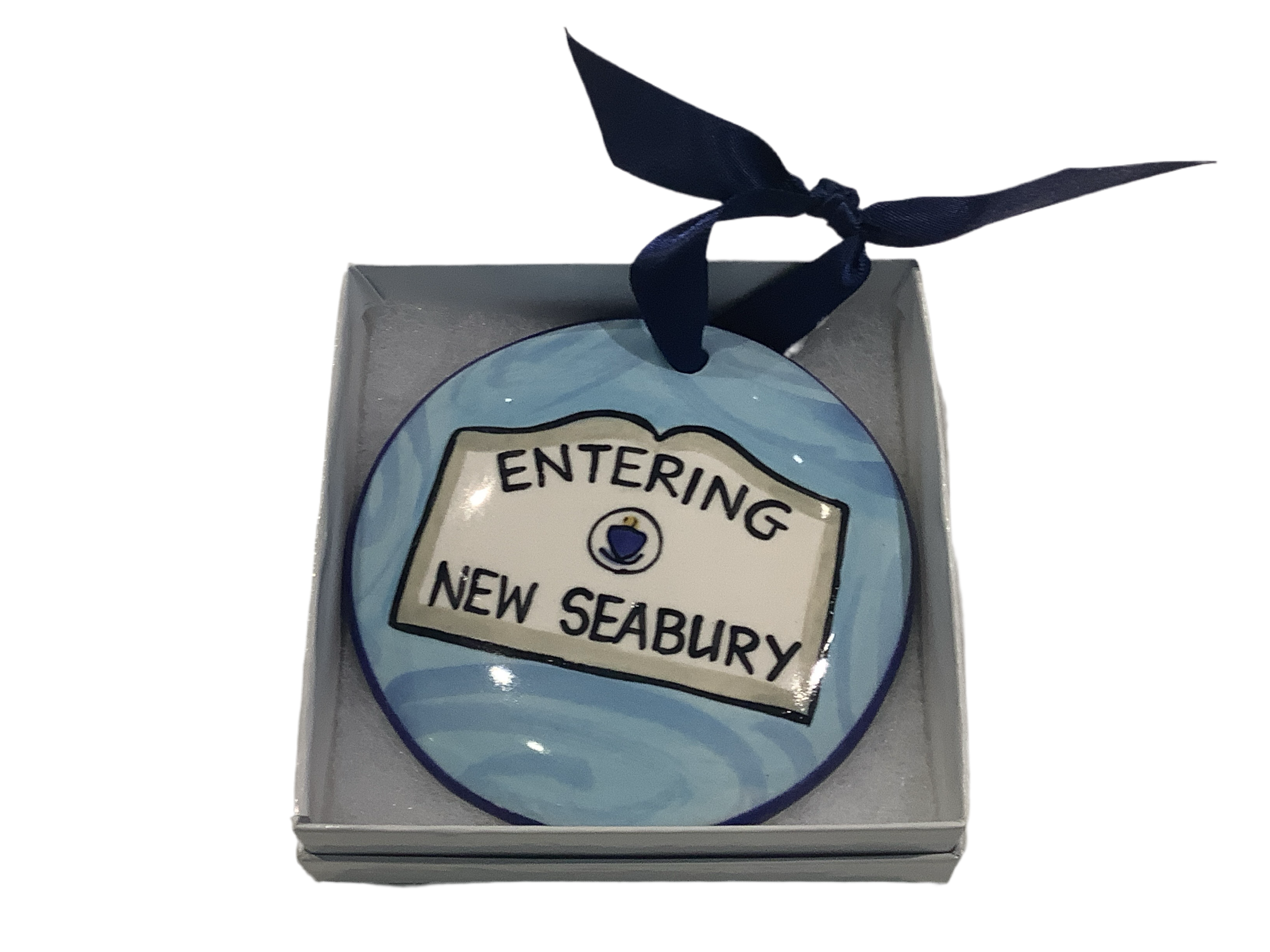 A round ceramic ornament with the text 'ENTERING NEW SEA BURY' painted on it, displayed in a box with a ribbon.