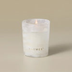 Thymes Frasier Fir Tidings 2 oz boxed votive candle in a swirling winter-white glass vessel with gold accents, displayed beside its green holiday gift box.