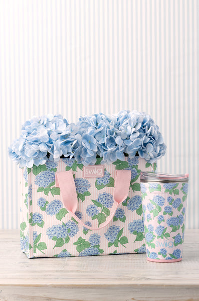 Swig Hydrangeas Reusable Gift Bag featuring clusters of soft blue hydrangeas on a blush and white pinstripe background
